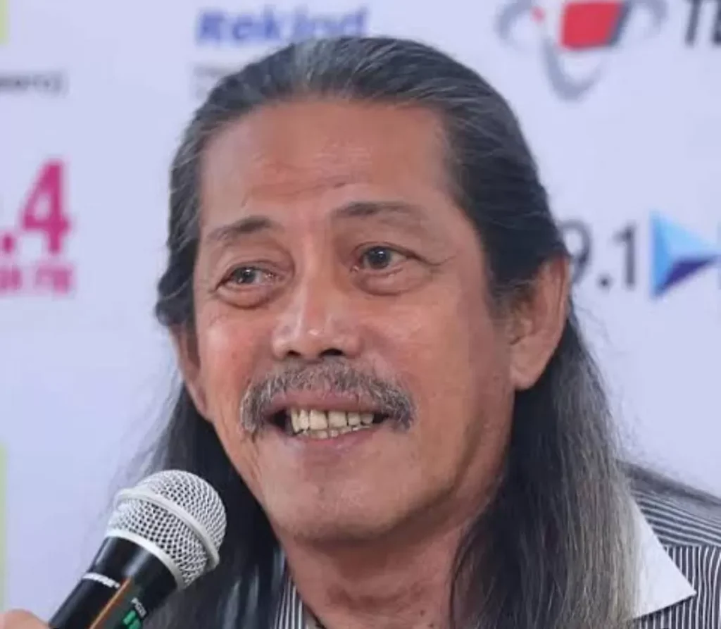 Acil Bimbo, musisi legendaris dari grup Bimbo, meninggal dunia pada usia 82 tahun. Foto ini menampilkan Acil Bimbo saat masih aktif di panggung, mencerminkan dedikasinya yang tak terbatas pada dunia musik dan hiburan